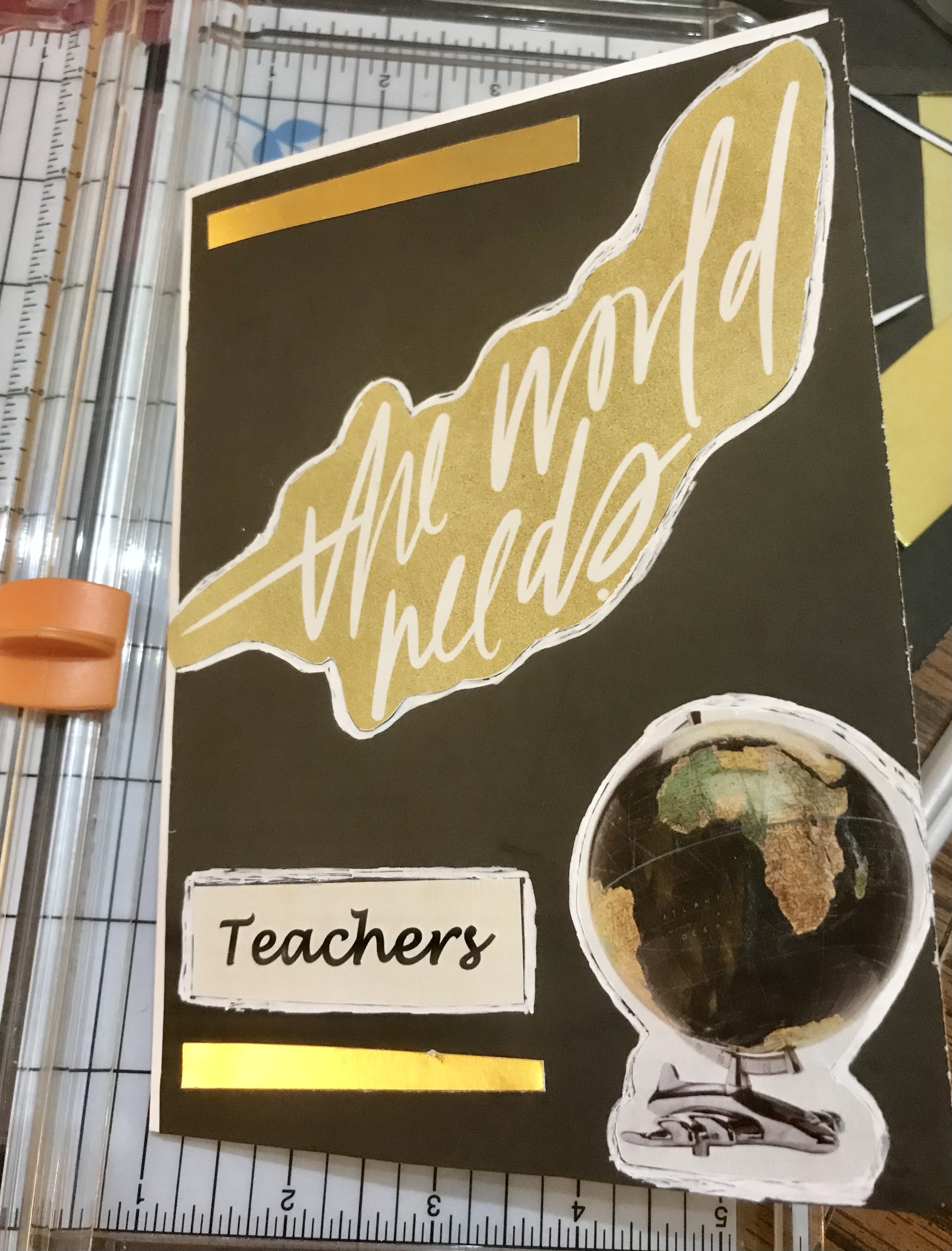 Homemade card with phrase "the world needs teachers" and globe of the world 